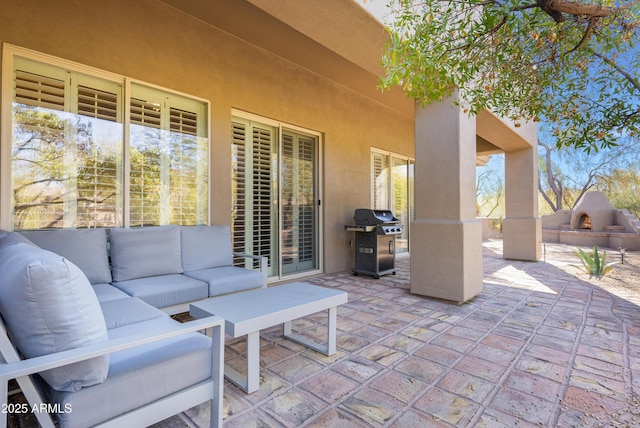 view of patio / terrace with an outdoor living space with a fireplace and area for grilling