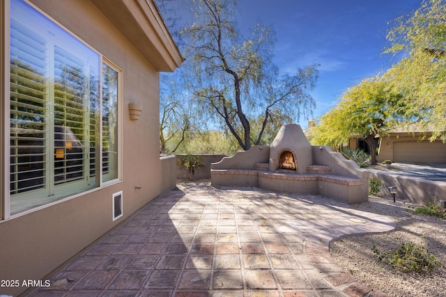 view of patio with exterior fireplace