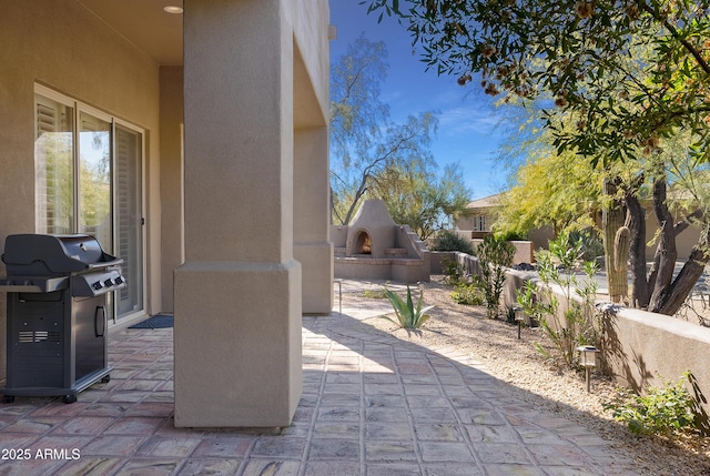 view of patio / terrace with exterior fireplace and area for grilling