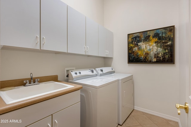 laundry area with cabinets, sink, light tile patterned floors, and separate washer and dryer