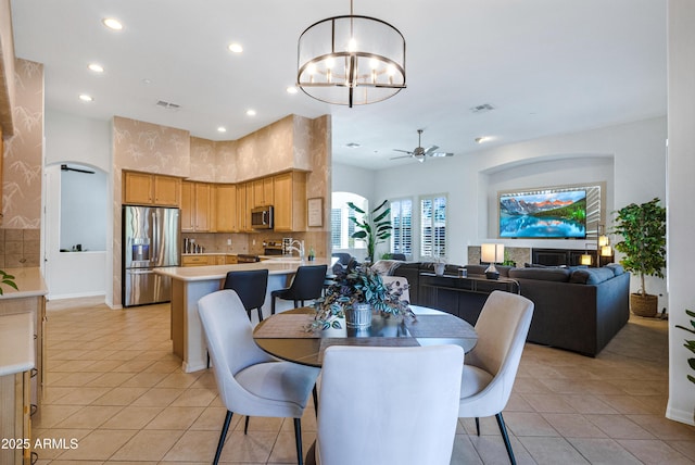 dining space featuring ceiling fan with notable chandelier and light tile patterned floors