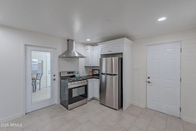 kitchen with white cabinetry, stainless steel appliances, and wall chimney exhaust hood