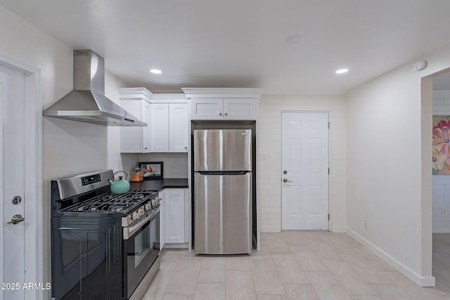 kitchen featuring wall chimney exhaust hood, white cabinetry, and appliances with stainless steel finishes