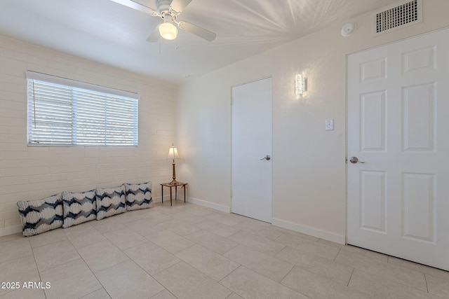 tiled spare room with ceiling fan