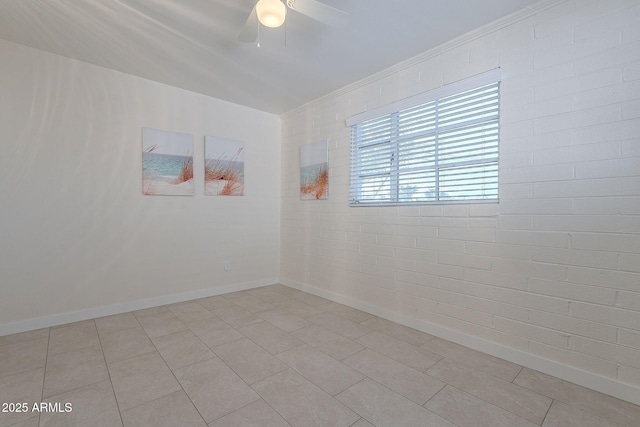 empty room featuring light tile patterned floors, ceiling fan, and brick wall