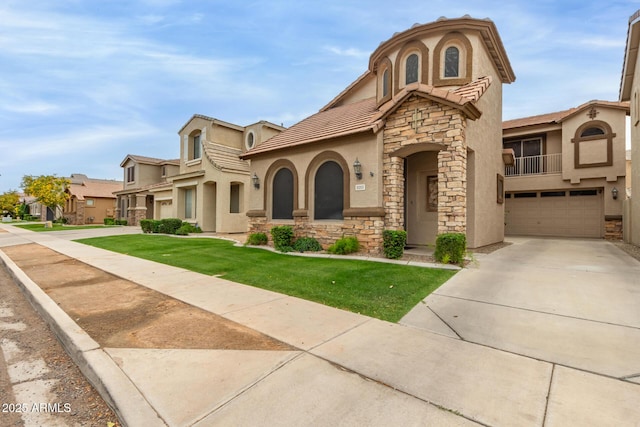 mediterranean / spanish-style house with stone siding, stucco siding, an attached garage, and a tiled roof