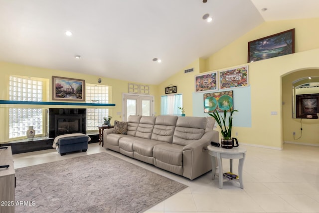 tiled living room featuring high vaulted ceiling