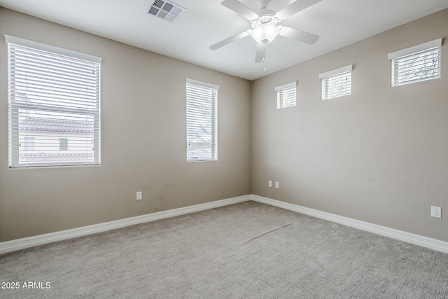 empty room featuring visible vents, baseboards, and ceiling fan