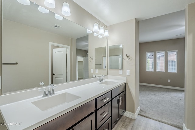 full bath featuring visible vents, wood finished floors, baseboards, and a sink