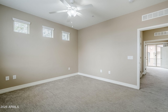 carpeted spare room featuring baseboards, a ceiling fan, and visible vents