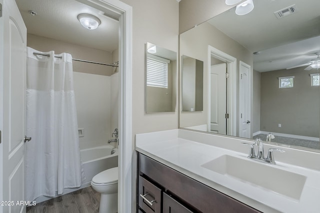 full bathroom featuring toilet, wood finished floors, visible vents, ceiling fan, and vanity