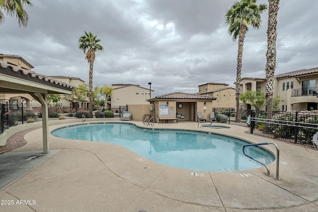 pool featuring a hot tub, fence, and a patio area