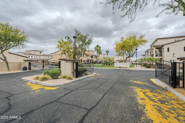 view of street with street lights, a residential view, a gated entry, and a gate
