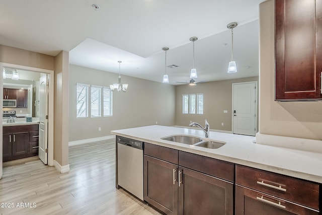 kitchen with hanging light fixtures, dark brown cabinetry, a sink, light wood-style floors, and appliances with stainless steel finishes