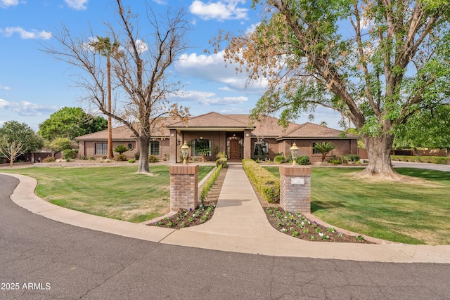 mediterranean / spanish home featuring a front lawn