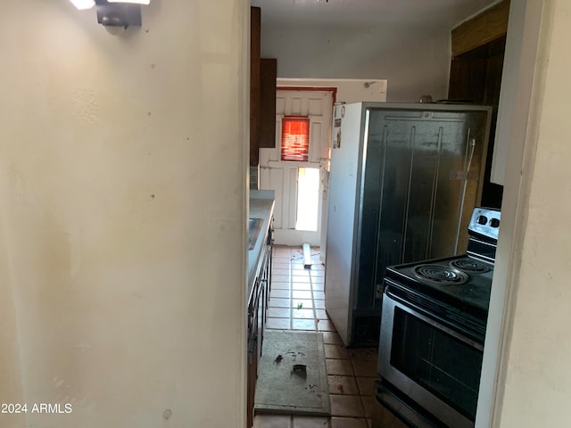 kitchen with stainless steel electric stove and tile patterned floors