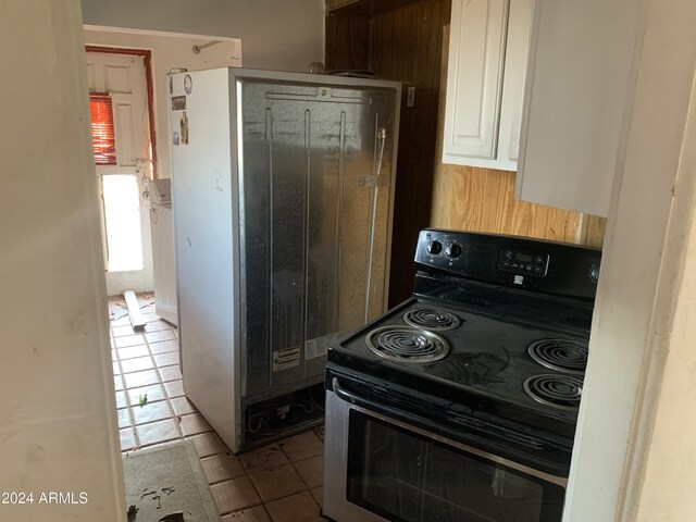 1202 S 14th St, Phoenix, AZ 85034 - kitchen with black electric range, tile patterned floors, refrigerator, and white cabinets