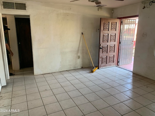 tiled empty room featuring ceiling fan