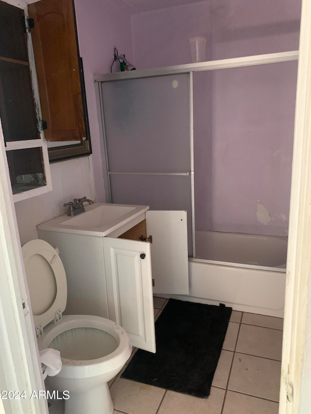 full bathroom featuring vanity, shower / bath combination with glass door, tile patterned floors, and toilet