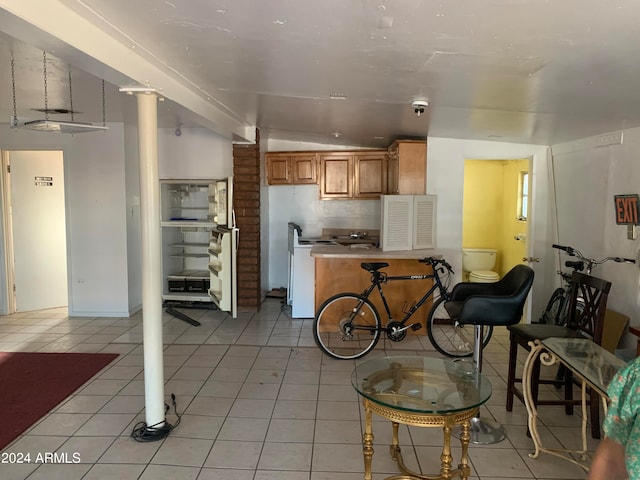 kitchen with vaulted ceiling, white range oven, light tile patterned floors, and tasteful backsplash