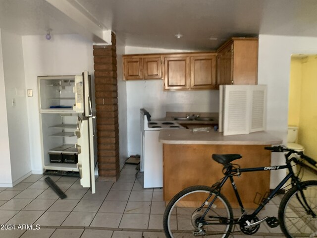 1202 S 14th St, Phoenix, AZ 85034 - kitchen featuring brown cabinetry, light tile patterned floors, white electric range, a peninsula, and light countertops