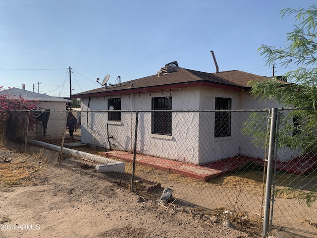 1202 S 14th St, Phoenix, AZ 85034 - back of house featuring stucco siding, fence, and a shingled roof