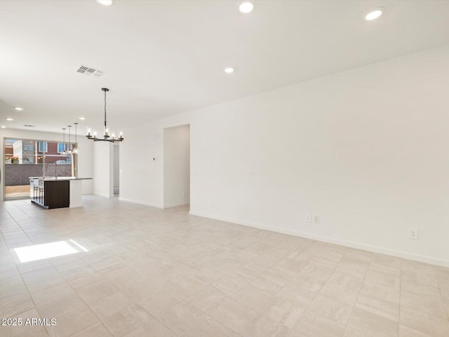 unfurnished living room featuring a notable chandelier, recessed lighting, visible vents, and baseboards