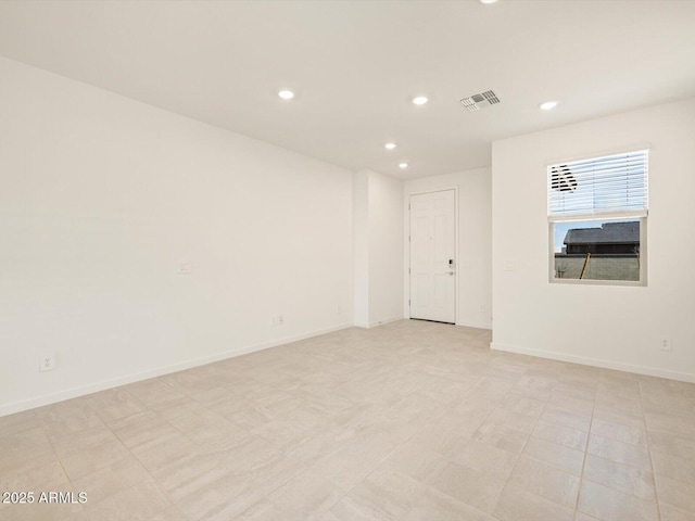 unfurnished room featuring baseboards, visible vents, and recessed lighting