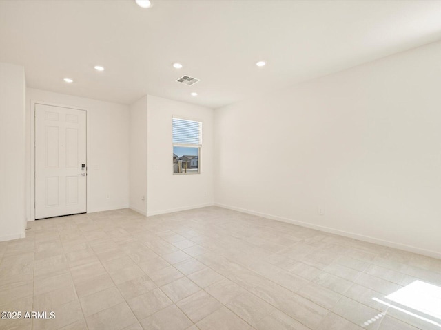 unfurnished room with baseboards, visible vents, and recessed lighting