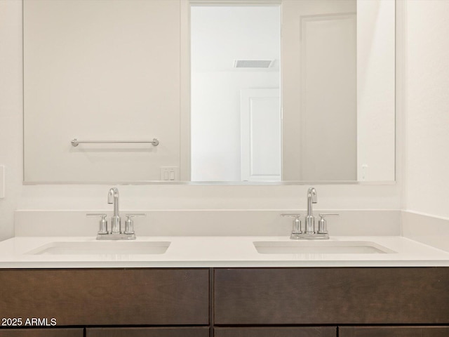 bathroom with double vanity, a sink, and visible vents