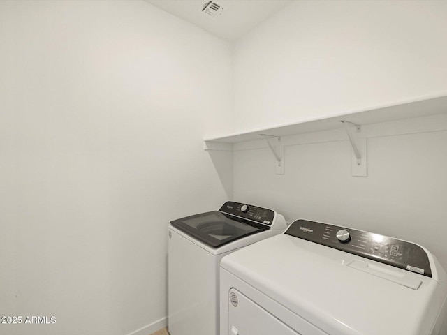 washroom featuring laundry area, baseboards, visible vents, and washer and dryer