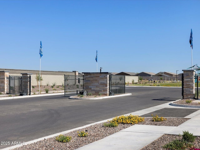 view of street featuring sidewalks, a gate, and curbs