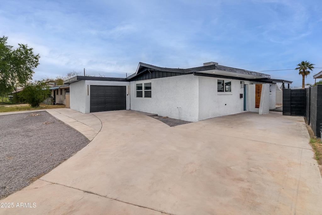 3002 W Mandalay Ln, Phoenix, AZ 85053 - view of front of property featuring a garage, driveway, stucco siding, and board and batten siding