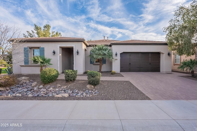 view of front of property with a garage, decorative driveway, and stucco siding