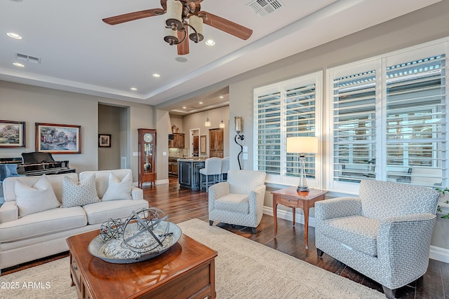 living room with visible vents, dark wood-style flooring, and recessed lighting