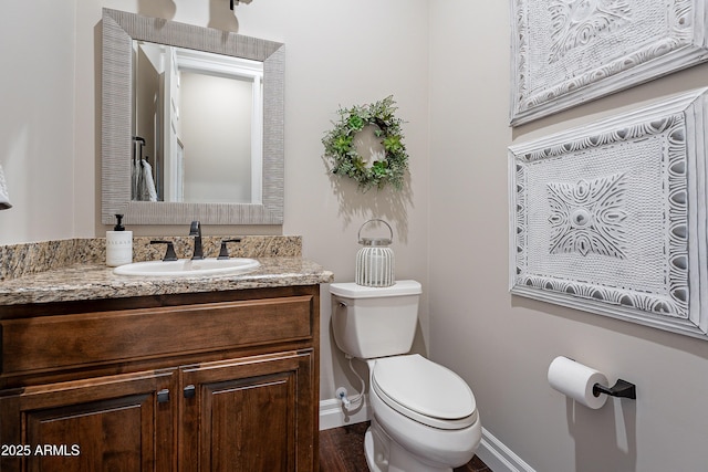 bathroom with baseboards, vanity, and toilet