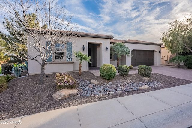 view of front of house with concrete driveway, an attached garage, and stucco siding