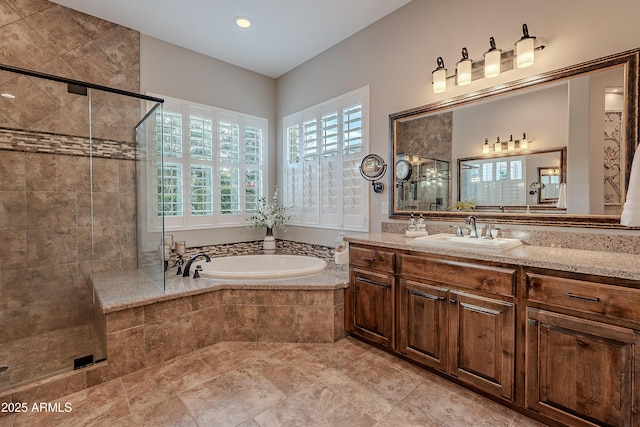 bathroom featuring a stall shower, a bath, and vanity