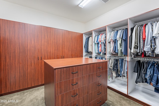 walk in closet featuring light colored carpet