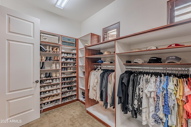 walk in closet featuring light carpet