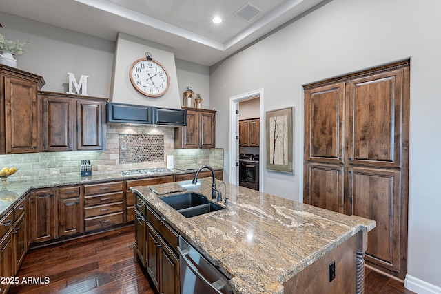 kitchen with visible vents, dark wood finished floors, an island with sink, stainless steel appliances, and a sink