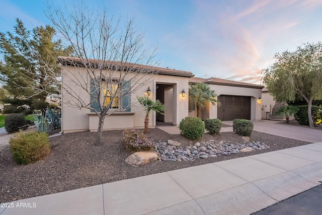 view of front of property with a garage, driveway, and stucco siding