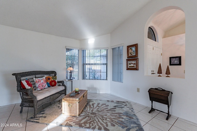 living area featuring a textured ceiling and light tile patterned flooring