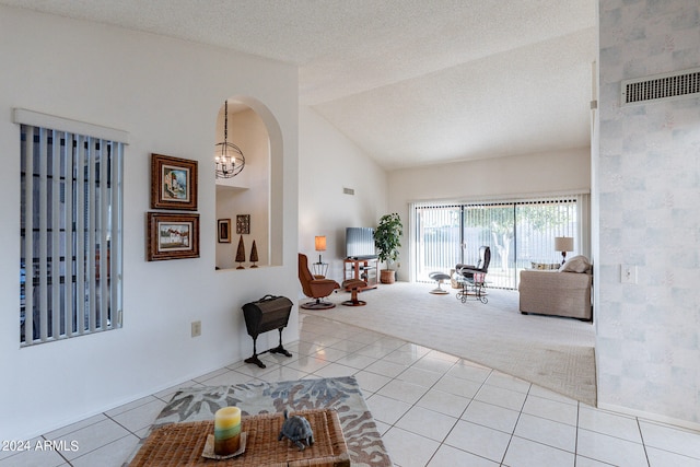 living room featuring high vaulted ceiling, a textured ceiling, and light tile patterned floors