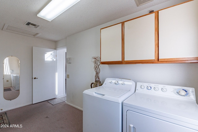 washroom with light carpet, a textured ceiling, washing machine and dryer, and cabinets