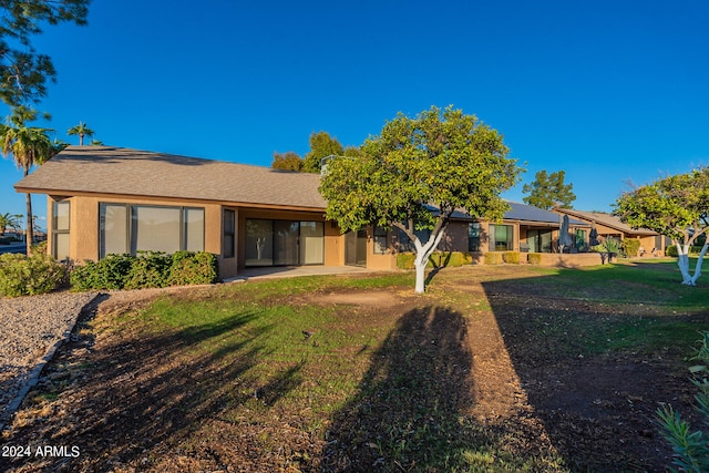 rear view of house featuring a lawn