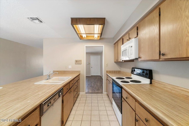 kitchen featuring a textured ceiling, light tile patterned flooring, white appliances, and sink