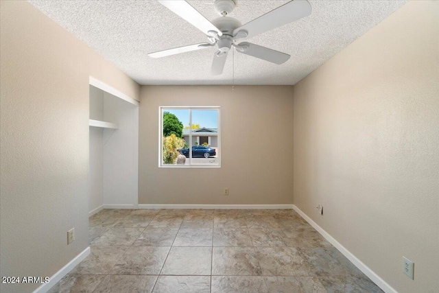 empty room with a textured ceiling and ceiling fan