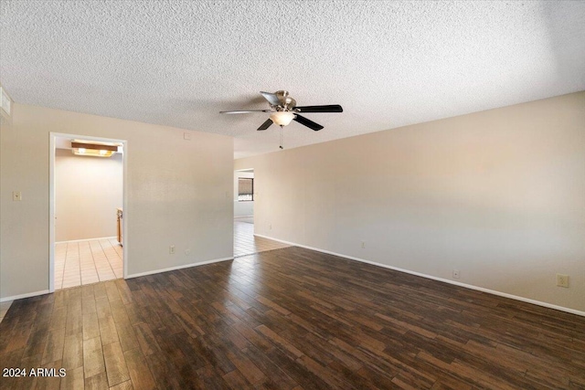 unfurnished room with a textured ceiling, ceiling fan, and dark wood-type flooring