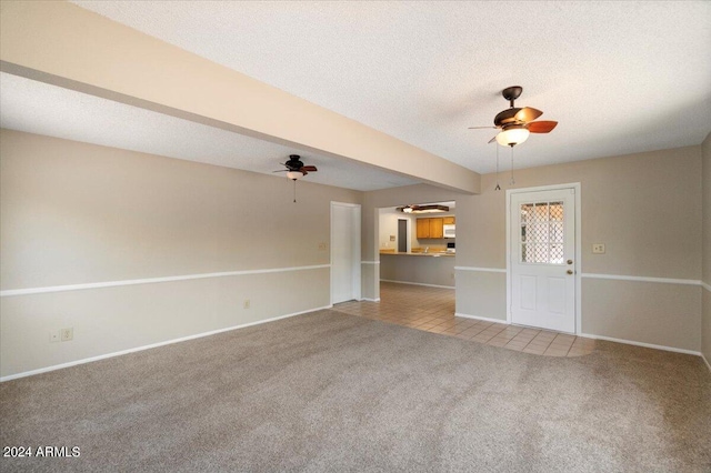 unfurnished living room with a textured ceiling and light carpet